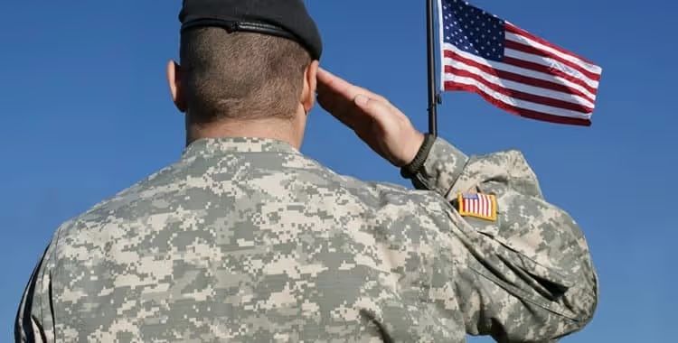 A soldier in uniform saluting the American flag