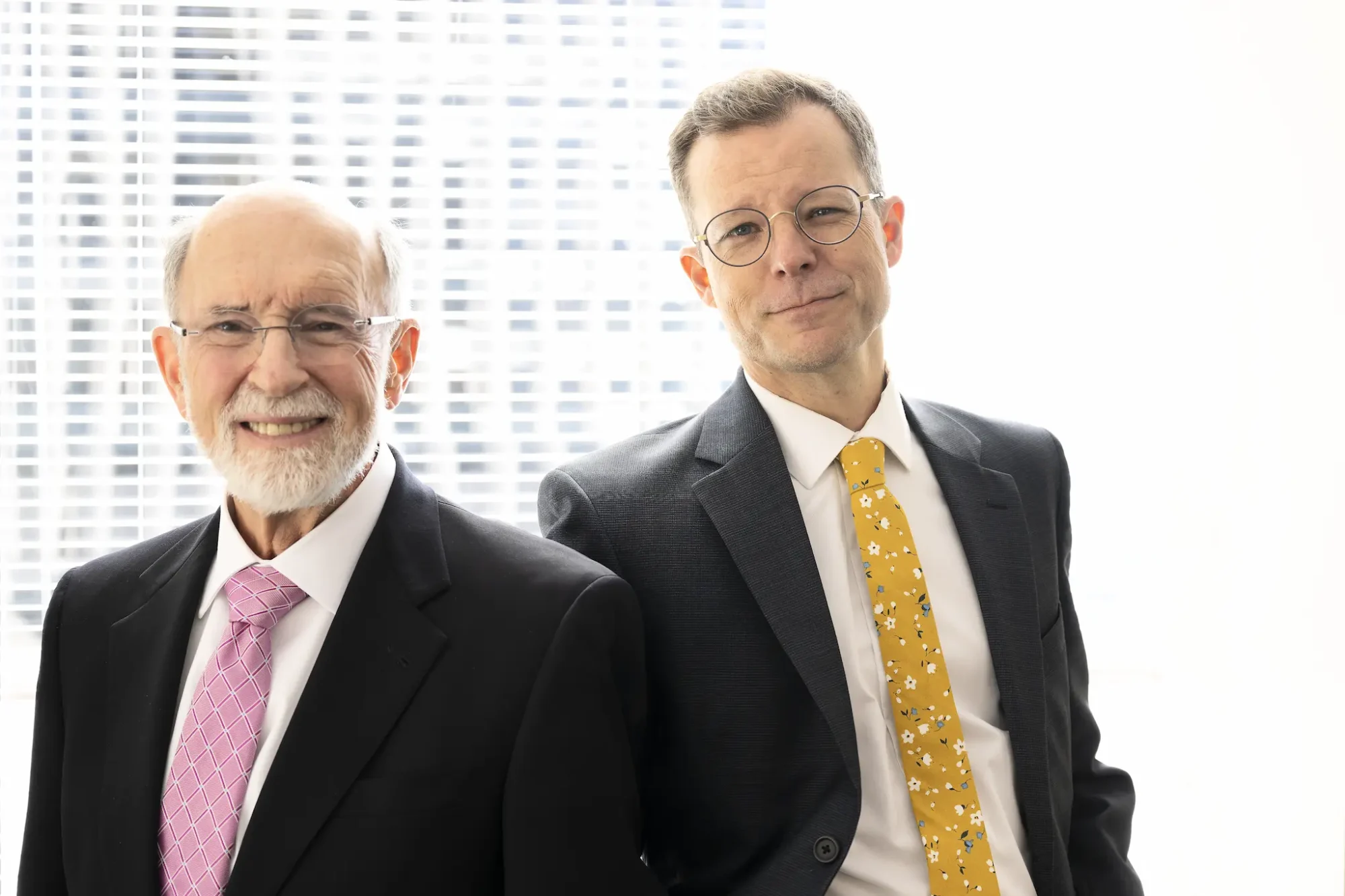 two men in suits and ties standing next to each other