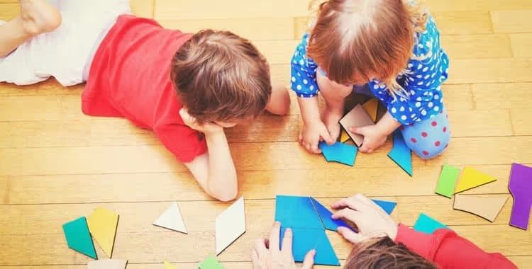 Children playing with shape puzzles on the floor